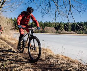 eine mountainbike gruppe fährt entlang eines sees im harz