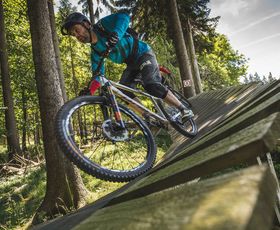 mountainiker fährt eine steilkurve im bikepark