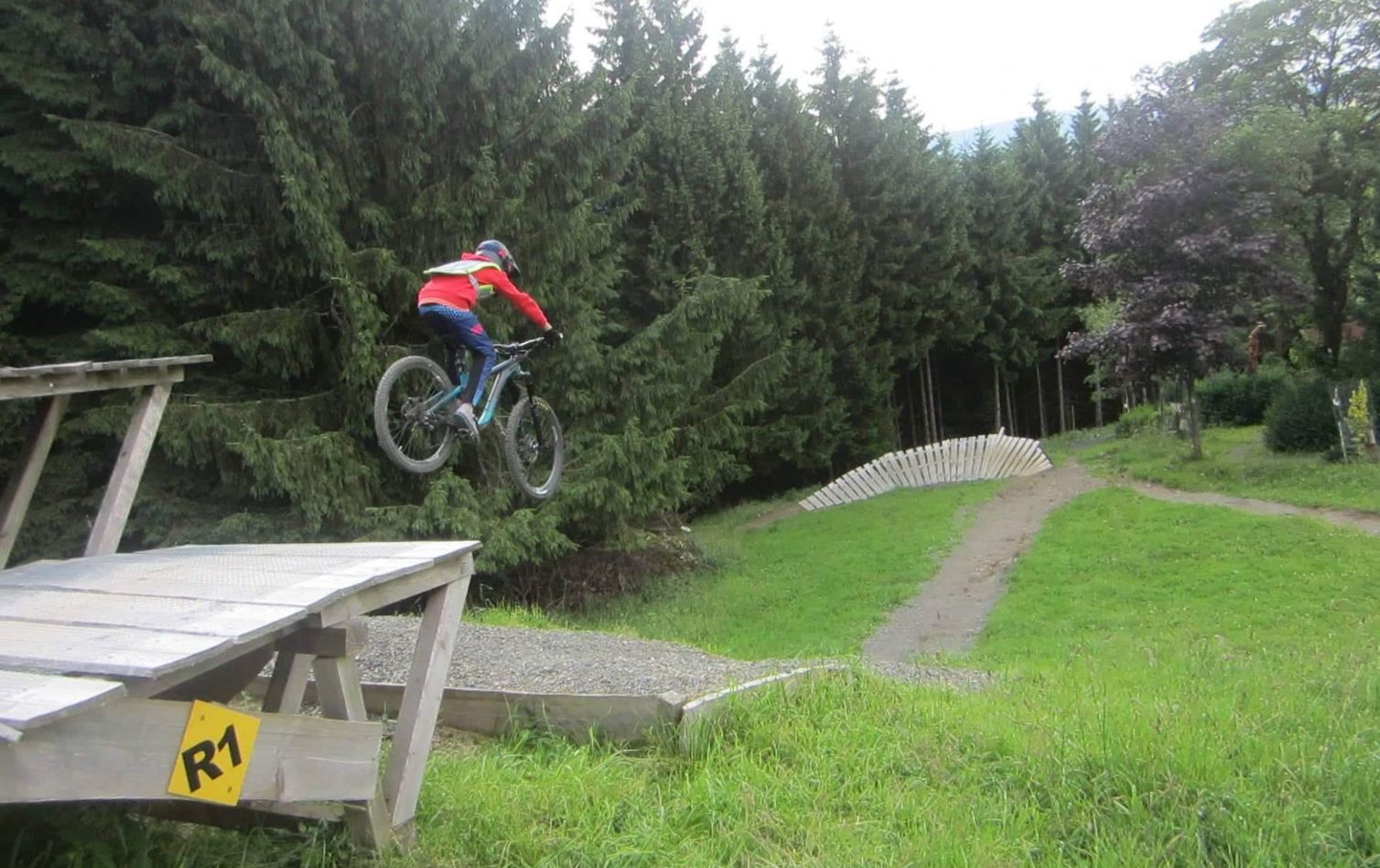ein jugendlicher springt mit mountainbike einen drop