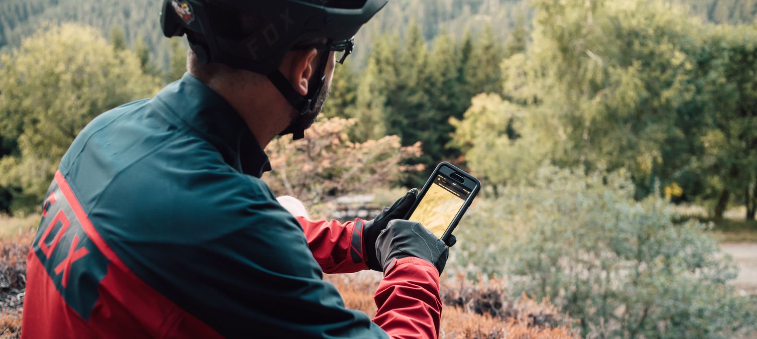 ein mountainbike guide sitzt auf einem felsvorsprung