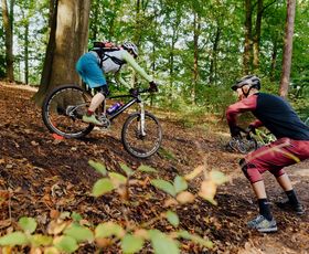 ein mountainbike trainer mit teilnehmerinn an einer übungsstelle