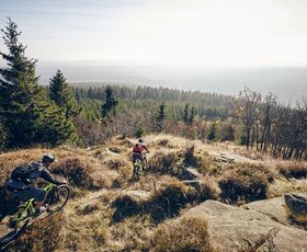 zwei mountainbiker fahren zwischen felsen hinab ins tal