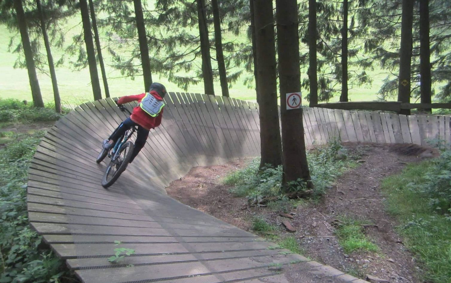 ein kind fährt eine steilkurve im bikepark