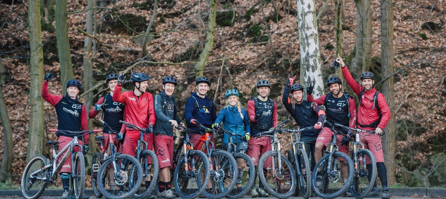 eine große gruppe mountainbiker winkt in die kamera