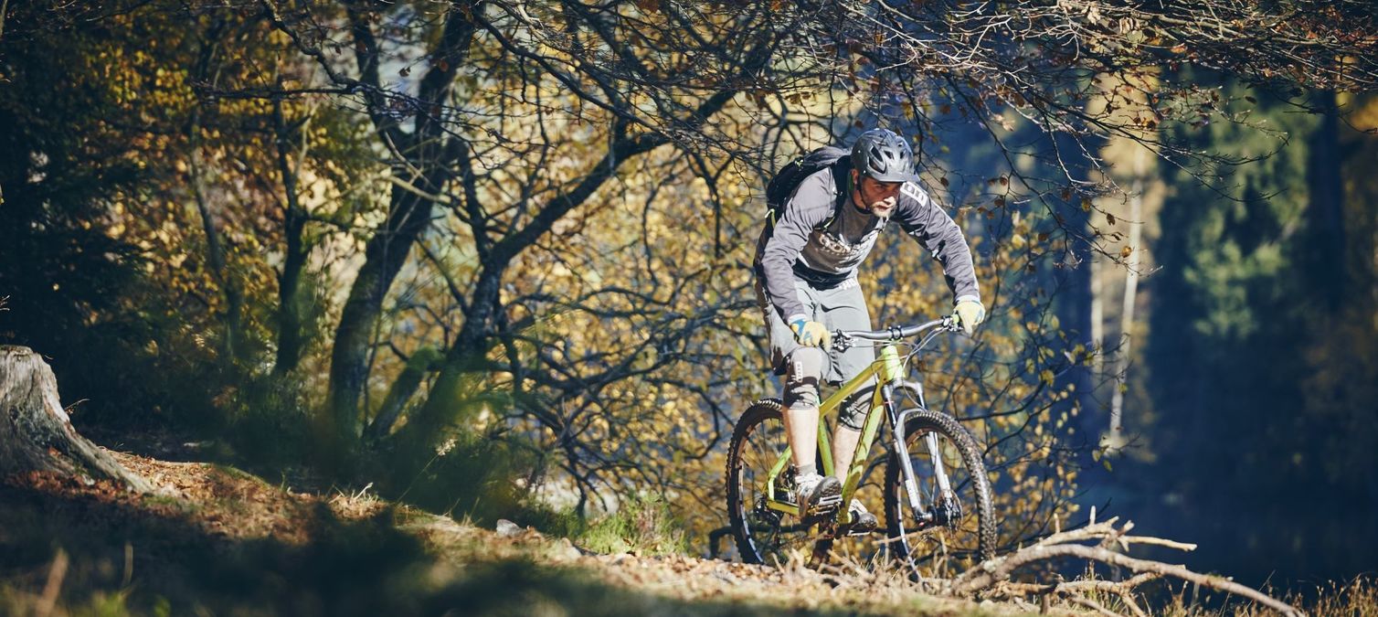 ein mountainbiker fährt entlang eines sees bei ilfeld