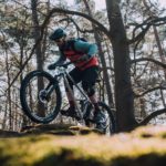 mountainbiker klettert über felsen
